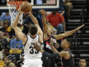 Memphis center Marc Gasol (33) shoots past Portland defenders C.J. McCollum, center, and Damian Lillard, right, in the first half of Game 1 on Sunday, April 19, 2015, in Memphis, Tenn.