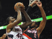 Portland Trail Blazers ' LaMarcus Aldridge (12) gets an elbow to the nose as Atlanta Hawks' Elton Brand (42) shoots in the first half of their NBA basketball game Thursday, March 27, 2014, in Atlanta.