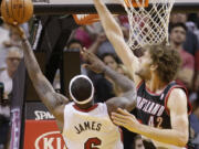 Miami Heat forward LeBron James (6) makes a shot against Portland Trail Blazers center Robin Lopez (42) in the final seconds of the second half of an NBA basketball game to defeat the Trail Blazers 93-91, Monday, March 24, 2014 in Miami.