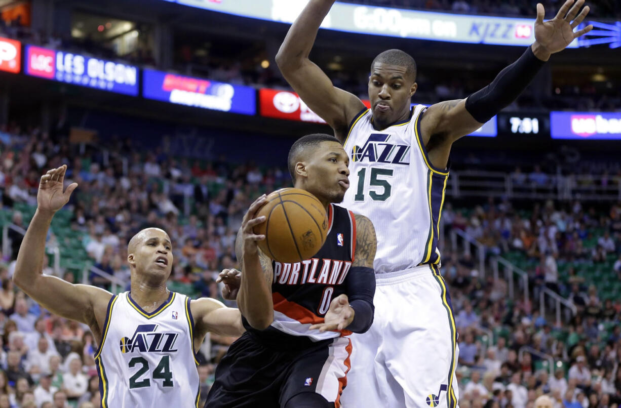 Portland Trail Blazers' Damian Lillard passes the ball as Utah Jazz's Richard Jefferson (24) and Derrick Favors (15) defend Friday in Salt Lake City.