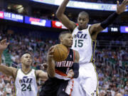 Portland Trail Blazers' Damian Lillard passes the ball as Utah Jazz's Richard Jefferson (24) and Derrick Favors (15) defend Friday in Salt Lake City.