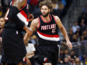 Portland Trail Blazers center Robin Lopez, right, is congratulated by teammates after hitting a basket against the Denver Nuggets in the fourth quarter of the Trail Blazers' 105-103 victory in an NBA basketball game in Denver on Tuesday, Dec. 2, 2014.