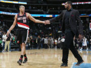 Portland Trail Blazers forward Nicolas Batum, left, of France, is congratulated by injured forward LaMarcus Aldridge after an NBA basketball game in Denver, Tuesday, Feb. 25, 2014. Portland won 100-95.