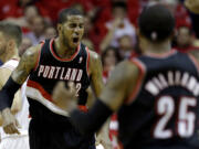 Portland Trail Blazers' LaMarcus Aldridge (12) reacts after making a basket while being fouled during the fourth quarter in Game 1 of an opening-round NBA basketball playoff series against the Houston Rockets  Sunday, April 20, 2014, in Houston. The Trail Blazers won 122-120 in overtime. (AP Photo/David J.