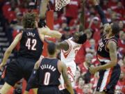 Houston Rockets' Patrick Beverley has a shot blocked as he drives against Portland Trail Blazers' LaMarcus Aldridge (12) and Robin Lopez (42) during the first half Sunday. (AP Photo/David J.