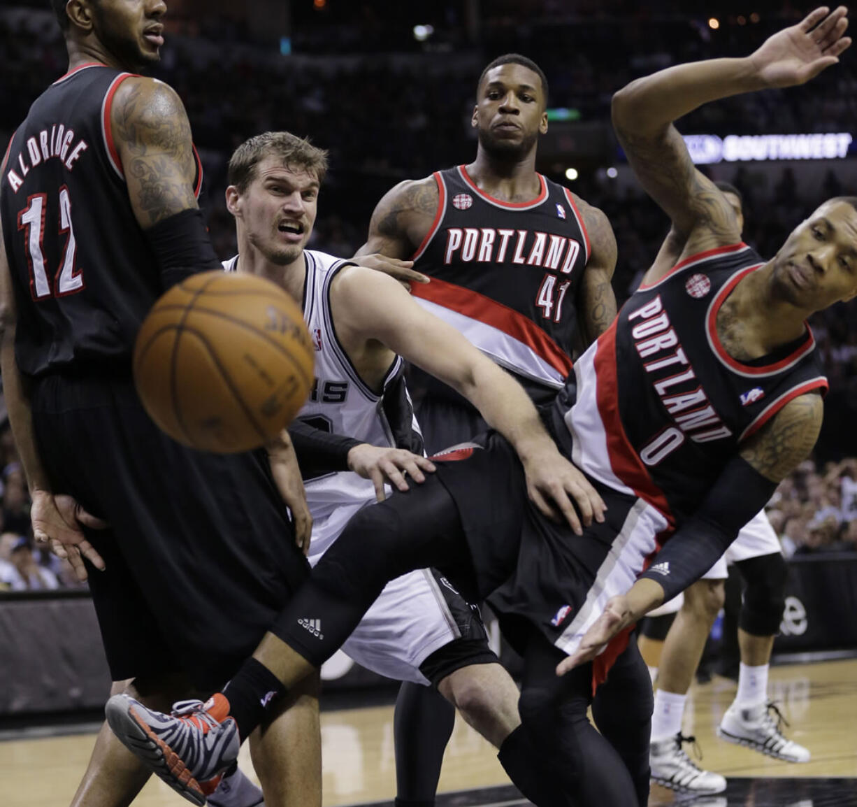 San Antonio Spurs' Tiago Splitter, center, of Brazil, battles Portland Trail Blazers' LaMarcus Aldridge (12), Thomas Robinson (41) and Damian Lillard (0) for a loose ball during the first half of Game 2 of a Western Conference semifinal NBA basketball playoff series, Thursday, May 8, 2014, in San Antonio.