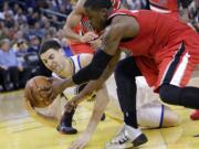 Golden State Warriors' Klay Thompson, left, fights for a loose ball against Portland Trail Blazers' Wesley Matthews, right, during the second half of an NBA basketball game on Sunday, Jan. 26, 2014, in Oakland, Calif. Golden State won 103-88.