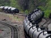 Workers inspect the scene April 30 after several CSX tanker cars carrying crude oil derailed and caught fire along the James River in Lynchburg, Va.