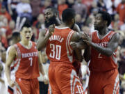 Houston Rockets guard Troy Daniels (30) celebrates with teammates James Harden, left, and Patrick Beverley after sinking a three point shot in overtime to take the lead during Game 3 Friday. The Rockets won 121-116.