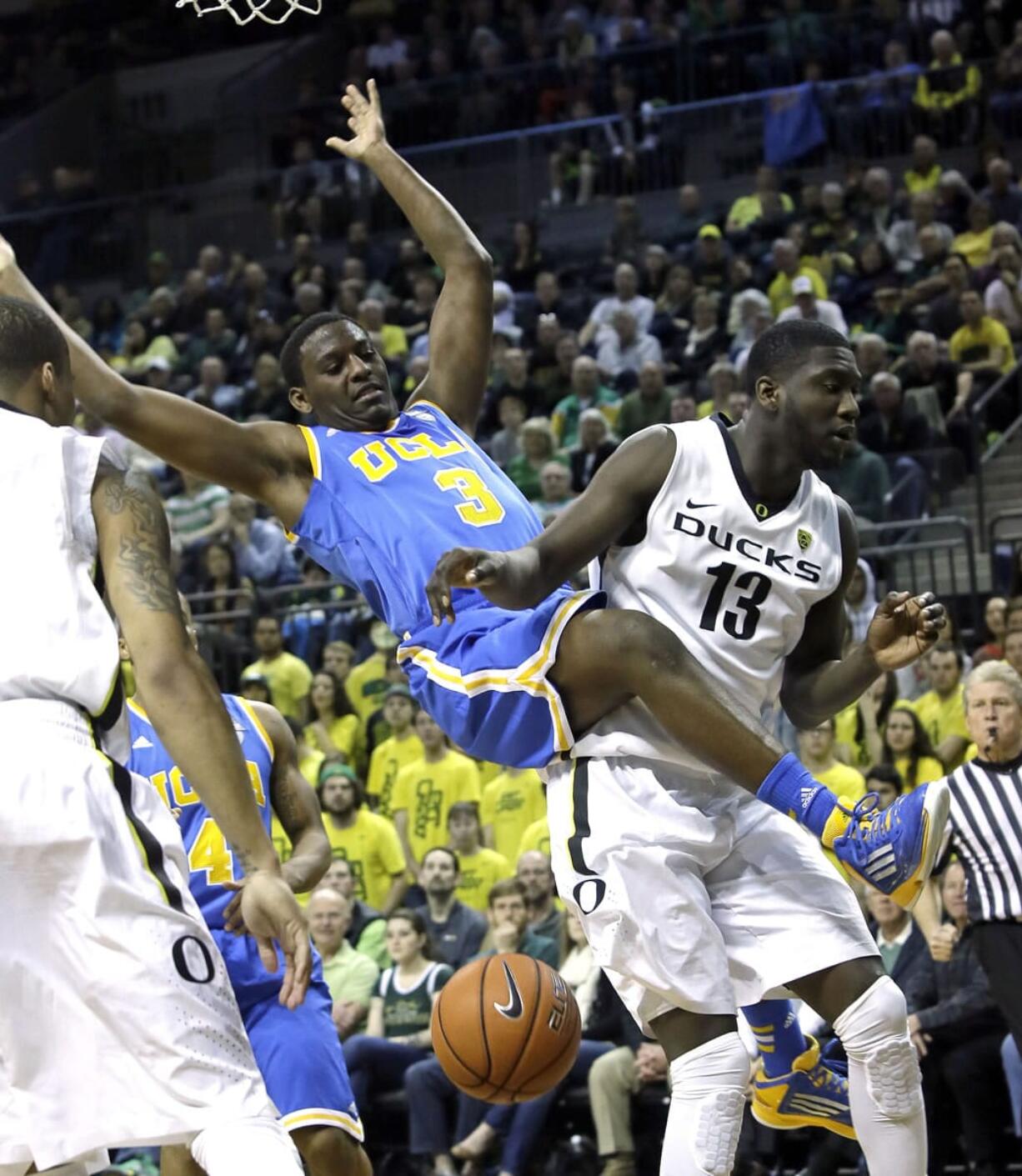 UCLA guard Jordan Adams, left, is fouled on his way to the basket by Oregon forward Richard Amardi.