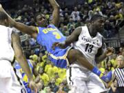 UCLA guard Jordan Adams, left, is fouled on his way to the basket by Oregon forward Richard Amardi.