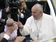 Pope Francis greets a baby as he arrives to Independence Mall, on Saturday, before delivering a speech in front of Independence Hall, in Philadelphia.