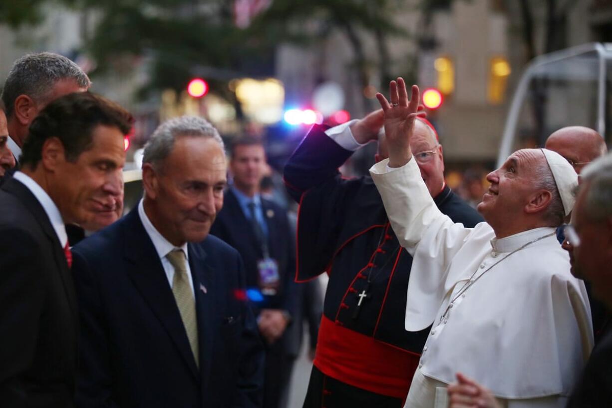 Pope Francis waves to the crowd as he arrives at St. Patrick's Cathedral on Thursday in New York. New York Gov. Andrew Cuomo, left, and Sen. Chuck Schumer, D-NY, wait to greet the pope.