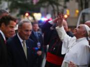 Pope Francis waves to the crowd as he arrives at St. Patrick's Cathedral on Thursday in New York. New York Gov. Andrew Cuomo, left, and Sen. Chuck Schumer, D-NY, wait to greet the pope.