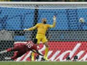 Portugal's Silvestre Varela heads the ball past United States' goalkeeper Tim Howard to score his side's second goal and tie the game 2-2 during the group G World Cup soccer match between the USA and Portugal at the Arena da Amazonia in Manaus, Brazil, Sunday, June 22, 2014.