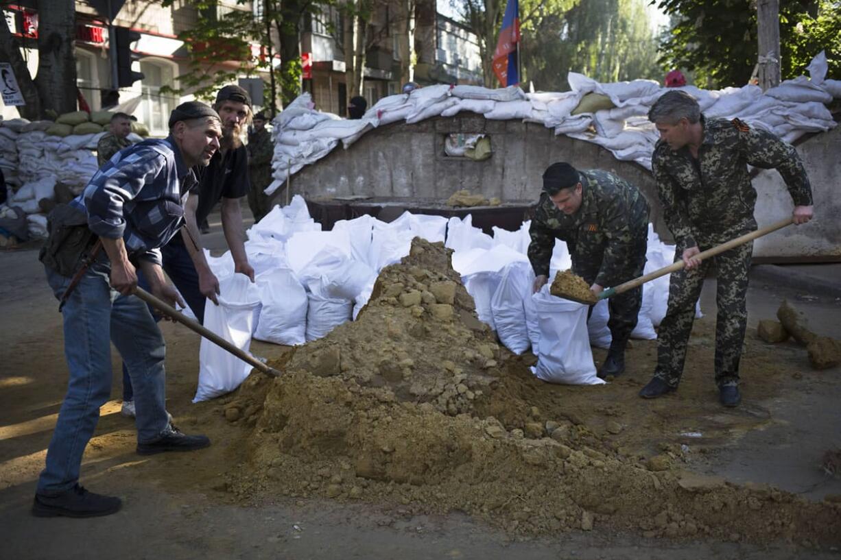 Pro-Russian activists strengthen the barricades in front of the Ukrainian regional office of the Security Service in Slovyansk, Ukraine, on Wednesday.