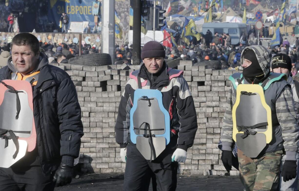 Opposition supporters dressed in hand-made bullet-proof vests arrive on Kiev's Independence Square to show their support for the opposition in Kiev, Ukraine, Friday. Ukraine's president gave in to pressure from European diplomats and offered concessions Friday to defuse a crisis that has divided his country and left scores dead.