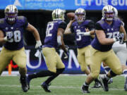 Washington quarterback Jake Browning (3) prepares to complete a pass to Dwayne Washington (12) as Jesse Sosebee, right, and Kaleb McGary, left, block against Utah State in the first half, Saturday, Sept. 19, 2015, in Seattle. (AP Photo/Ted S.