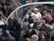 Pope Francis gives the thumbs up as he is driven through the crowd in his pope-moblie for for his weekly general audience in St.