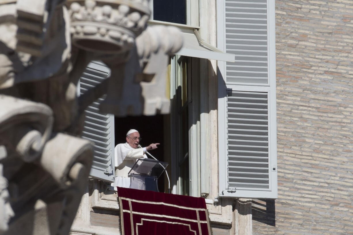 Pope Francis delivers his speech during the Angelus noon prayer he delivered from the window of his studio overlooking St.