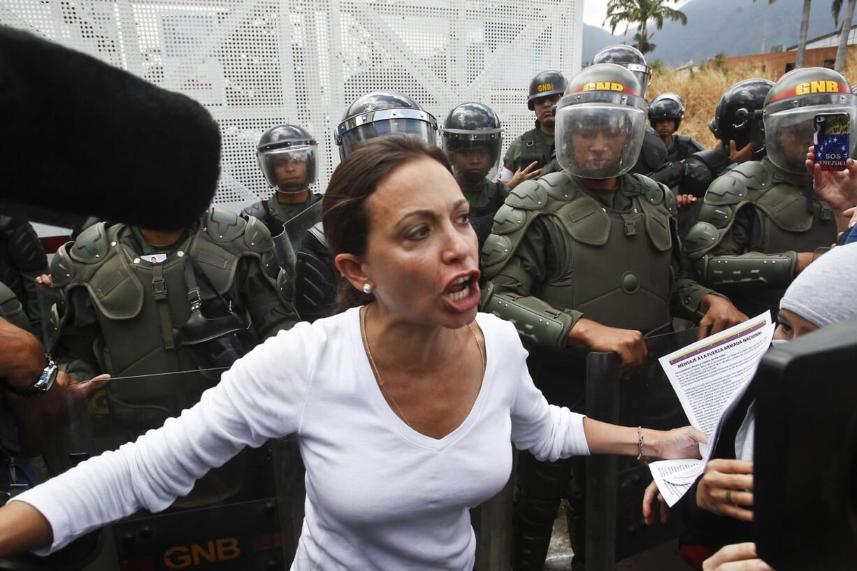 Opposition Congresswoman Maria Corina Machado speaks to the media and supporters in front of a line of Bolivarian National Guards during an anti-government march in Caracas, Venezuela, on Sunday.