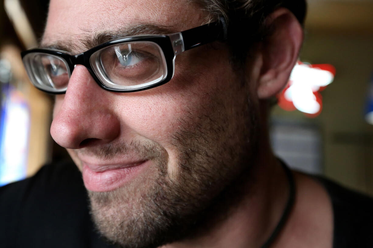 In this photo taken on Thursday, Sept. 3, 2015, Alexander Miller smiles at the Pine St. Pub in Salem, Ore. Miller, 30, has been legally blind for most of his life, but now has 20/30 vision thanks to new glasses.