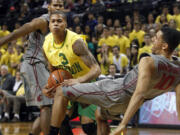 Oregon's Joseph Young (3) is fouled as he drives to the basket between Washington State defenders Royce Woolridge, left, and Dexter Kernich-Drew on Sunday in Eugene.