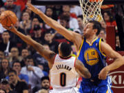 Portland Trail Blazers guard Damian Lillard (0) drives to the basket on Golden State Warriors center Andrew Bogut (12) during the first half Sunday.