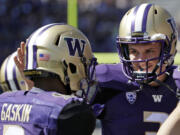 Washington's Myles Gaskin (9) is congratulated on the last of his three touchdowns against Sacramento State by quarterback Jake Browning, right, during the second half in Seattle. Washington won 49-0.