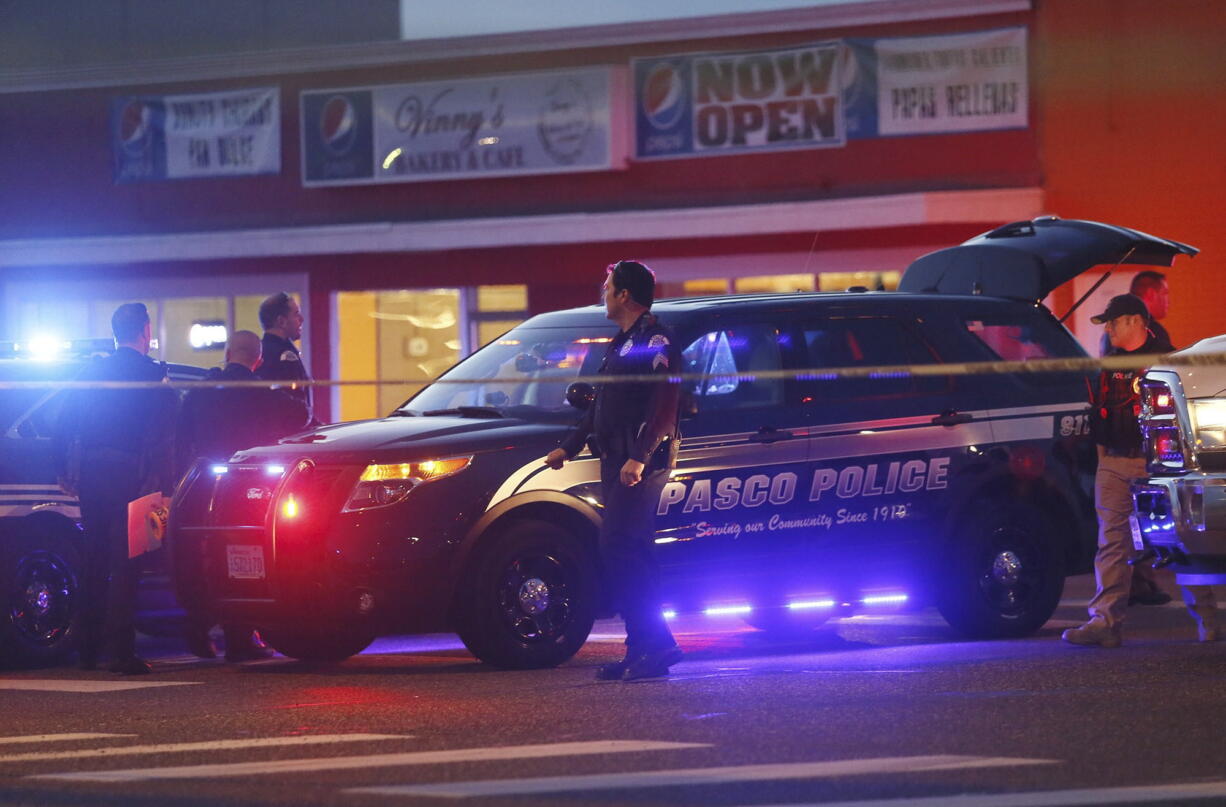 Pasco Police officers investigate the scene of the Feb. 10 shooting of Antonio Zambrano-Montes, who was shot by police in Pasco. A prosecutor says three police officers in Washington state who fatally shot a rock-throwing Mexican immigrant in February will not face criminal charges.