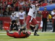 Washington State quarterback Luke Falk (4) evades Rutgers defensive lineman Quanzell Lambert (22) as he runs for yardage late in the second half of an NCAA college football game, Saturday, Sept. 12, 2015, in Piscataway, N.J. Washington State won 37-34.