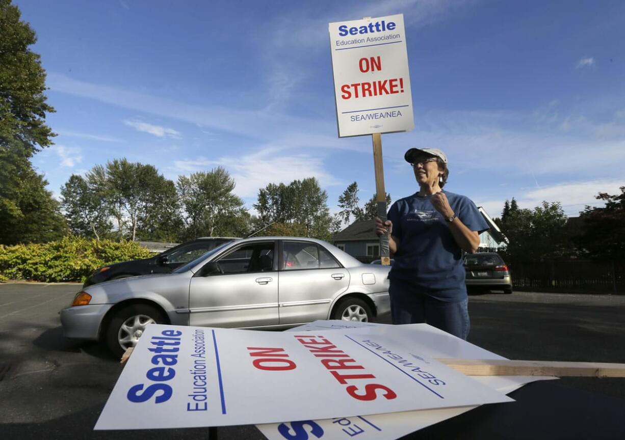 Nancy Kiser, a fifth-grade teacher at Kimball Elementary School, examines a picket sign to be used in the event of a strike by teachers in the Seattle School District, Tuesday, Sept. 8, 2015, in Seattle. Seattle teachers voted overwhelmingly last week to strike if the district and teachers fail to reach a contract agreement by the first day of school on Wednesday. (AP Photo/Ted S.