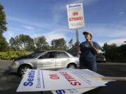 Nancy Kiser, a fifth-grade teacher at Kimball Elementary School, examines a picket sign to be used in the event of a strike by teachers in the Seattle School District, Tuesday, Sept. 8, 2015, in Seattle. Seattle teachers voted overwhelmingly last week to strike if the district and teachers fail to reach a contract agreement by the first day of school on Wednesday. (AP Photo/Ted S.