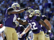 Washington Huskies running back Lavon Coleman (22) is congratulated after scoring against Eastern Washington in the first half of an NCAA football game Saturday, Sept. 6, 2014, in Seattle.