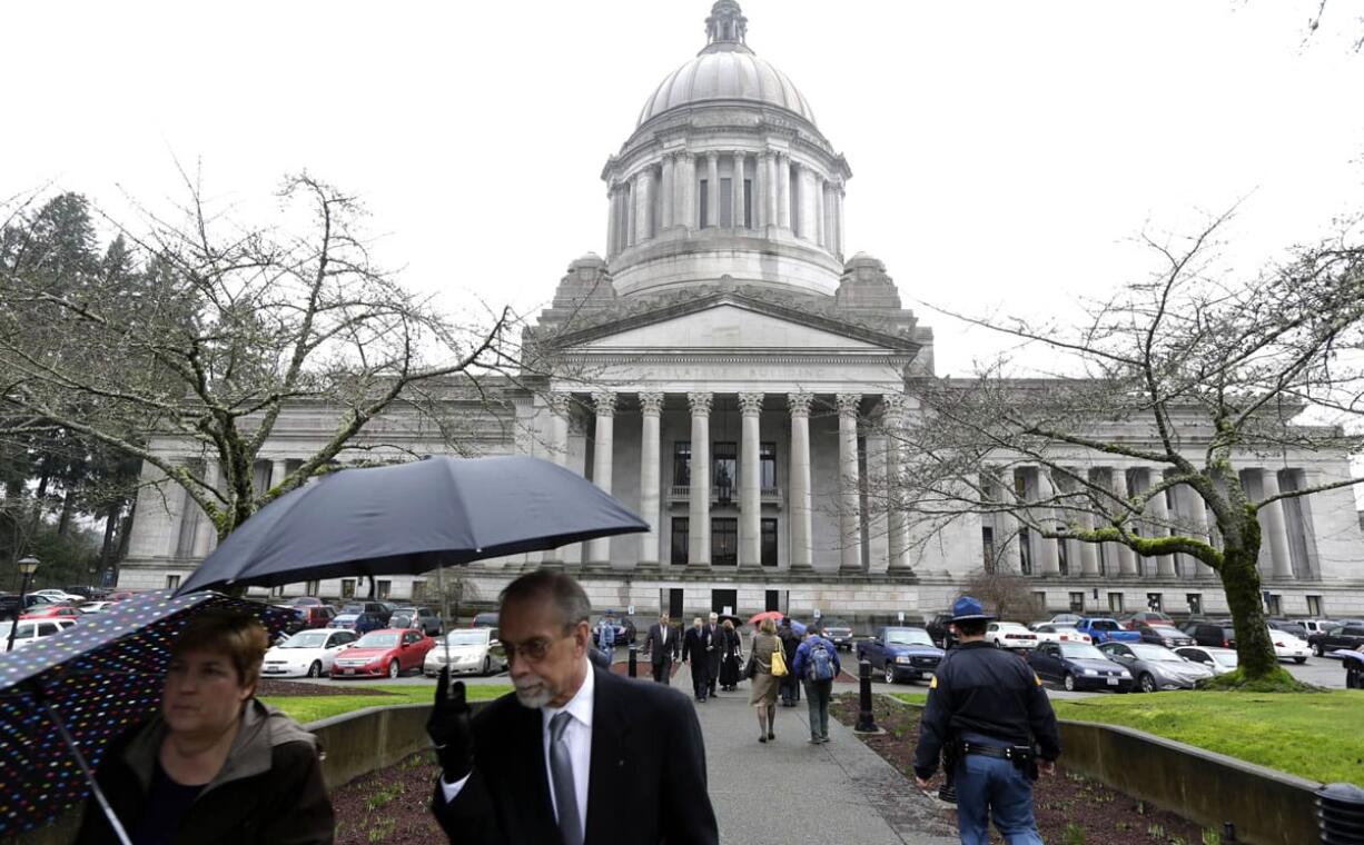 A sidewalk outside the Legislative building is bustling with people on the first day of the 2014 session of the Washington state Legislature on Monday at the Capitol in Olympia.