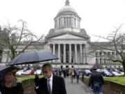 A sidewalk outside the Legislative building is bustling with people on the first day of the 2014 session of the Washington state Legislature on Monday at the Capitol in Olympia.