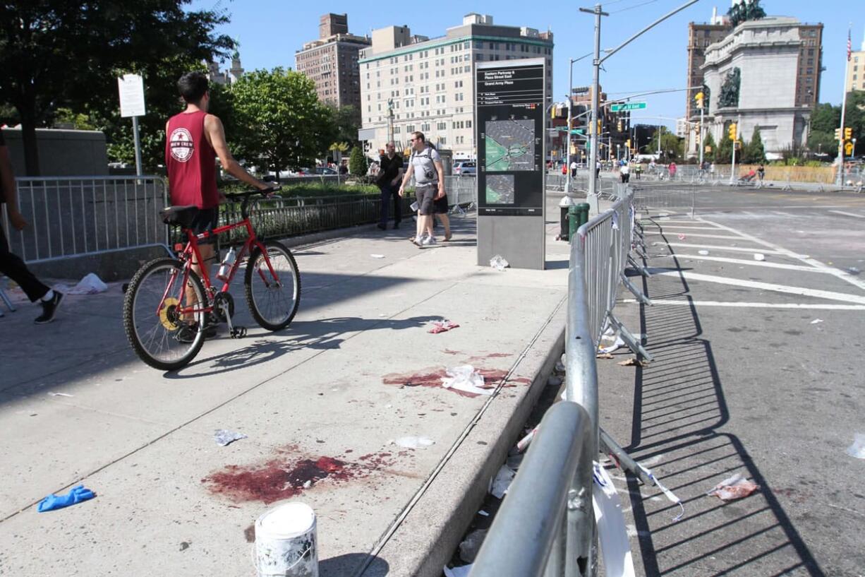 Blood stains remain on a sidewalk Monday where earlier a 24-year-old man was stabbed to death at Grand Army Plaza in the Brooklyn borough of New York, before the start of the West Indian Day Parade.