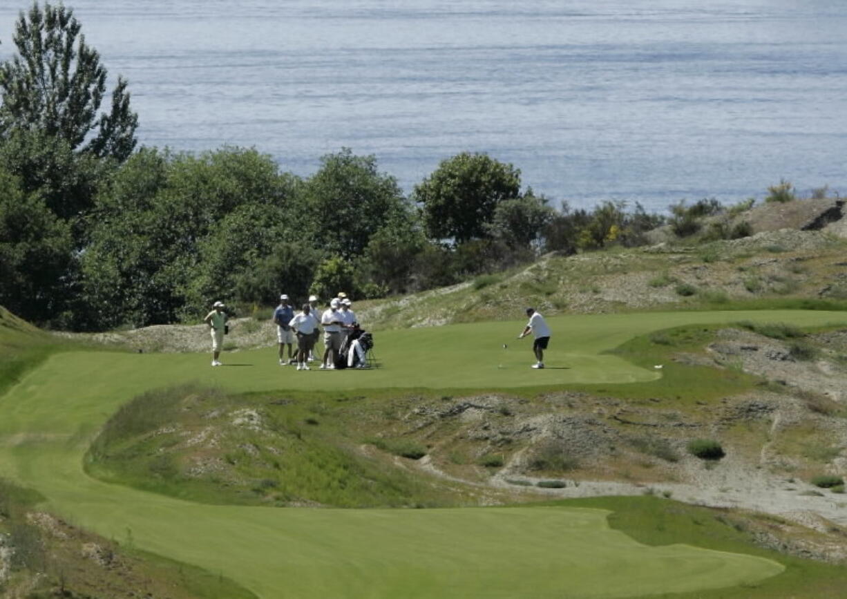 A group of golfers, with Puget Sound in the background tees, off from the 5th tee of the Chambers Bay Golf Course in University Place near Tacoma.