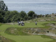 A group of golfers, with Puget Sound in the background tees, off from the 5th tee of the Chambers Bay Golf Course in University Place near Tacoma.