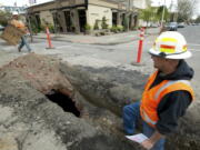 Jimm Grandstaff, left, with Integrity Excavation and Construction, and Mike Steuben, with the City of Vancouver Water dept., work near a cistern discovered at 12th and Main in downtown Vancouver.