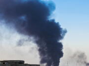 A column of smoke rises from an oil refinery in Beiji, some 250 kilometers north of Baghdad, Iraq, after an attack by Islamic militants on July 31.