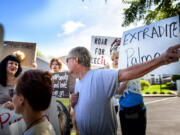 Demonstrators heckled one of Walter Palmer's patients, Thomas Dressel, right, who paused to speak to the media, outside Palmer's dental practice Tuesday in Bloomington, Minn.  One said &quot;I bet he has a confederate flag in his car window.&quot;  He pointed out that he did not. Palmer, after weeks out of the public eye, was the subject of an international uproar after he was identified as the hunter who killed the famous lion Cecil, in Zimbabwe.