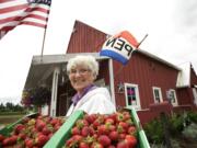 Carol Hoffman, owner of Red Barn, holds a flat of Hood strawberries outside her business in May in Vancouver. &quot;The customers prefer the Hood flavor,&quot; said Hoffman.