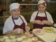 Washougal: Hathaway Elementary School student Danielle Melton, left, and Gause Elementary School student Mackenzie Mills take part in a live cooking competition March 13, 2014, at Washougal High School.