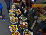 Kia Lor, of C&amp;K's Flower Garden, grabs a bouquet for a customer during the opening weekend of the Vancouver Farmers Market, which is celebrating its 25th season this year.