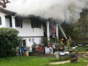 Firefighters work on extinguishing a fire at a home near Lewisville Park.