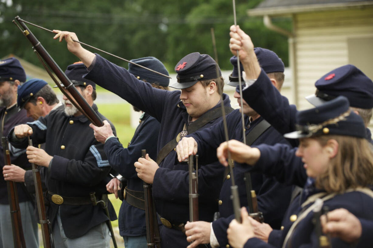 1st Oregon Volunteer Infantry reenactors load their rifles during a soldiers bivouac demonstration at Vancouver Barracks.