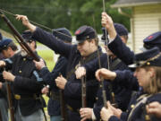 1st Oregon Volunteer Infantry reenactors load their rifles during a soldiers bivouac demonstration at Vancouver Barracks.