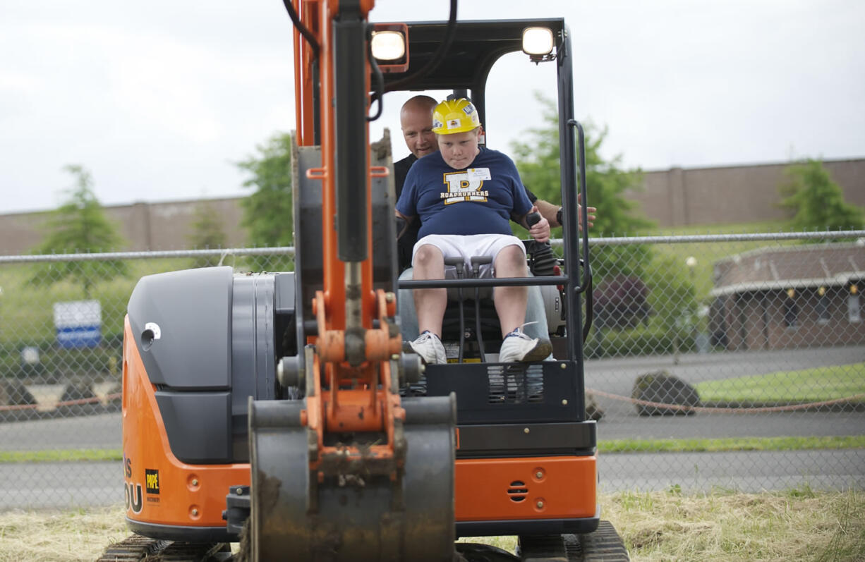 Clark County Event Center at the Fairgrounds: Riverview Elementary School student Thomas Stores, 11, gets a lesson in scooping and dumping dirt by Nutter Corp.