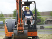 Clark County Event Center at the Fairgrounds: Riverview Elementary School student Thomas Stores, 11, gets a lesson in scooping and dumping dirt by Nutter Corp.